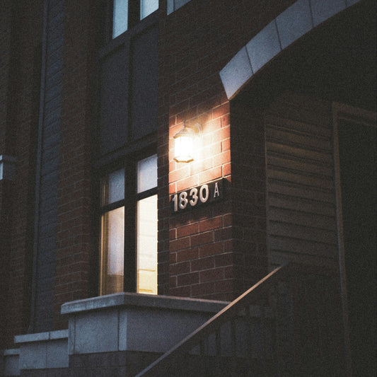 Building entrance with a light fixture and number '1830A' at night.